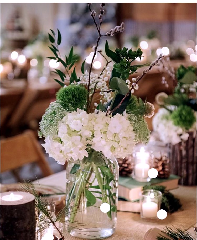 White hydrangea and greenery centerpiece in a glass jar